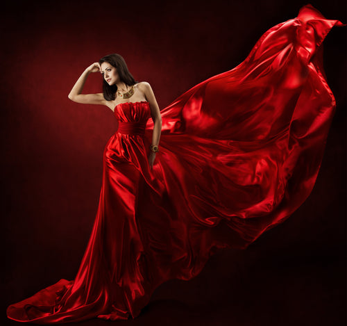 Woman posing gracefully in a stylish red long dress
