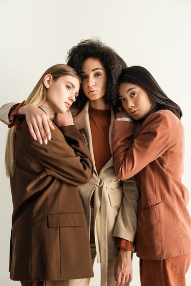 Three female fashion models In a group hug